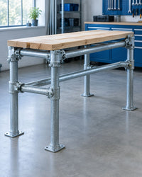 Galvanised scaffold tube workbench assembled with right-angle and swivel couplers in a workshop